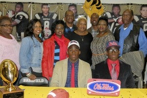 THE PRENTISS HEADLIGHT / The Moore twins, AJ & CJ, signed an athletic scholarship with University of Mississippi. Standing (l to r) Kashina Graves, Martha Thompson and mother Monica Moore, Ruby Booth, Unique Thompson, grandfather Melvin Moore, father Alvin Moore and grandfather K.D. Barnes. Seated are BHS athletes Calvin (CJ) and Alvin (AJ) Moore.