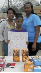 Shirley Burnham / The Prentiss Headlight—Parent helper Dionna Evans, Troop member Javia Newsome and Troop Leader Lafarrah Newsome worked on selling their last stash of Girl Scout cookies in front of Rameys in Prentiss.